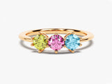 Gold ring with three colorful gemstones: yellow, pink, and blue