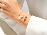 Gold bracelets with colorful gemstones on a woman's wrist