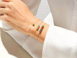 Gold bracelets with colorful gemstones on a woman's wrist