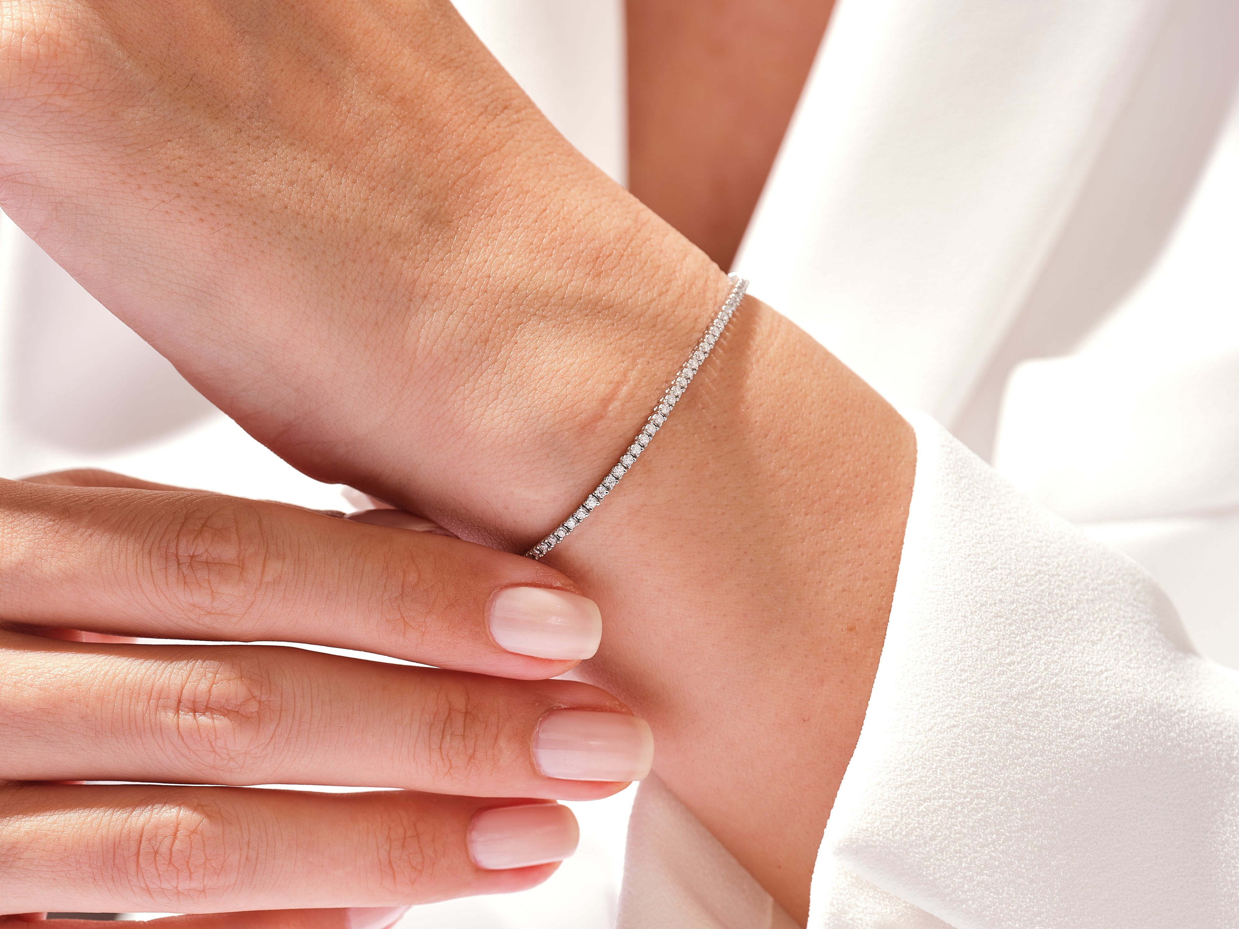 Diamond tennis bracelet on a woman's wrist, fine jewelry