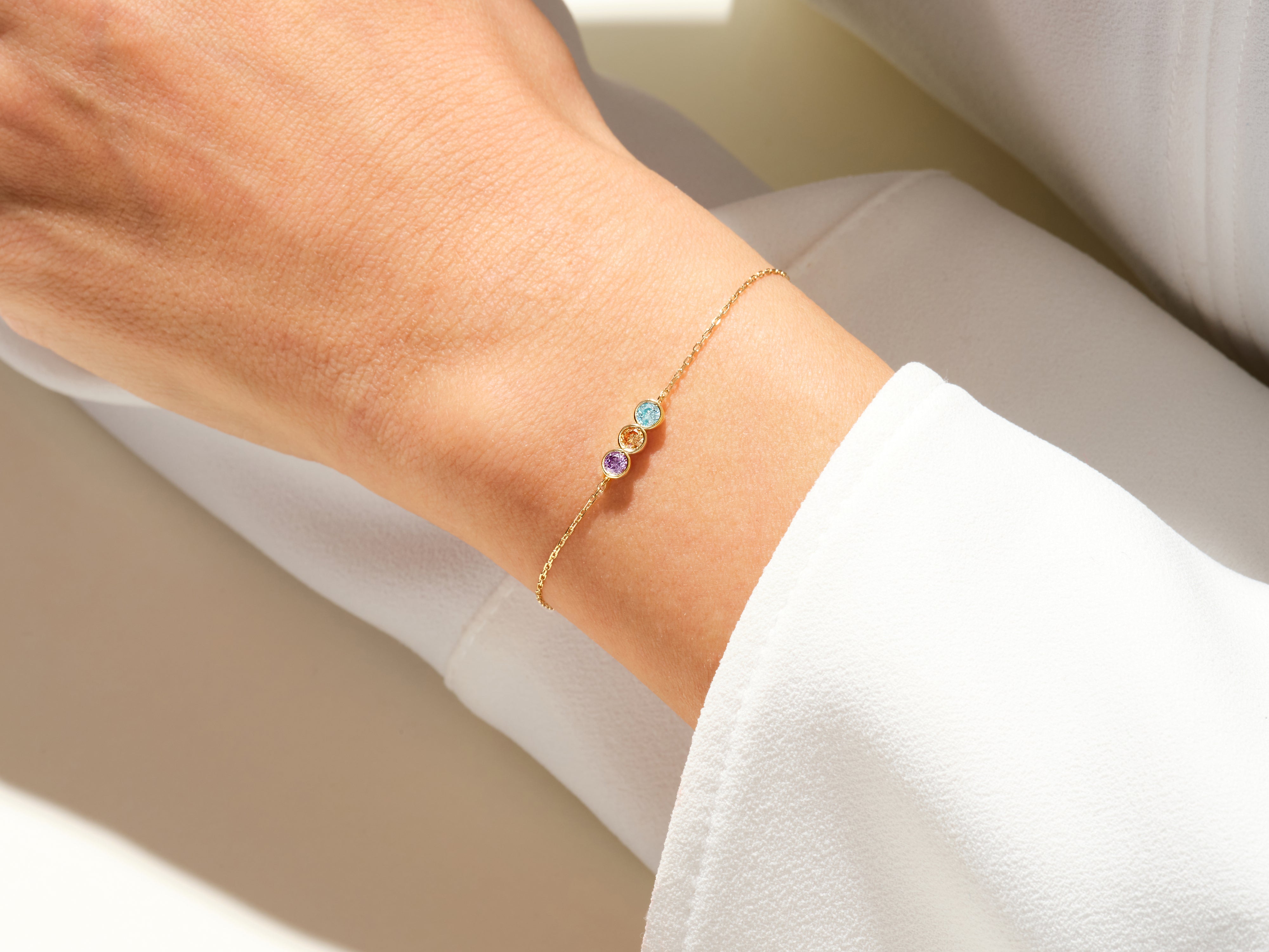 Gold bracelet with colorful gemstones on a woman's wrist