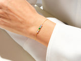 Gold bracelet with colorful gemstones on a woman's wrist
