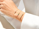 Gold chain bracelets with colorful gemstones on a hand