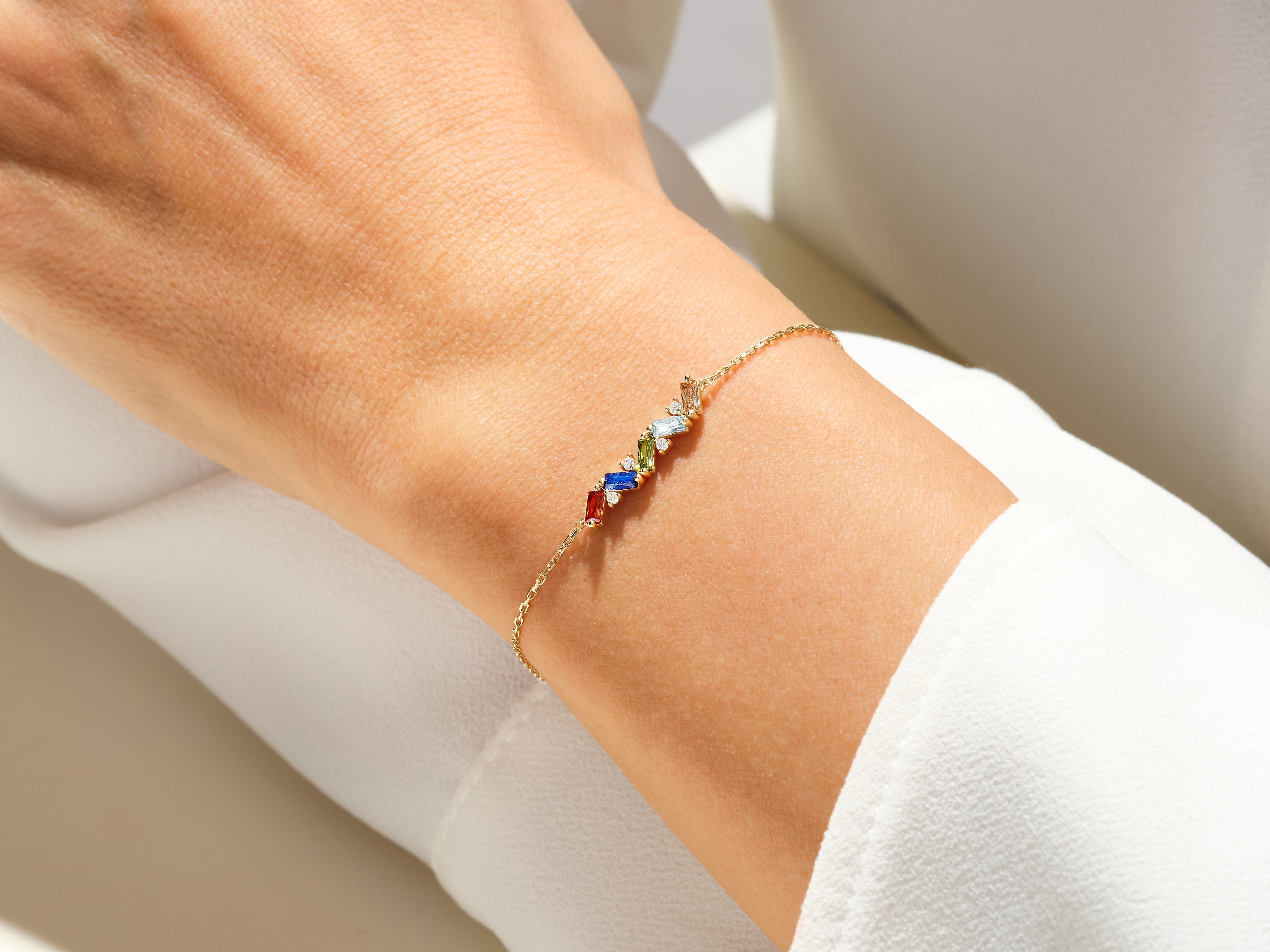 Gold bracelet with colorful gemstones on a wrist