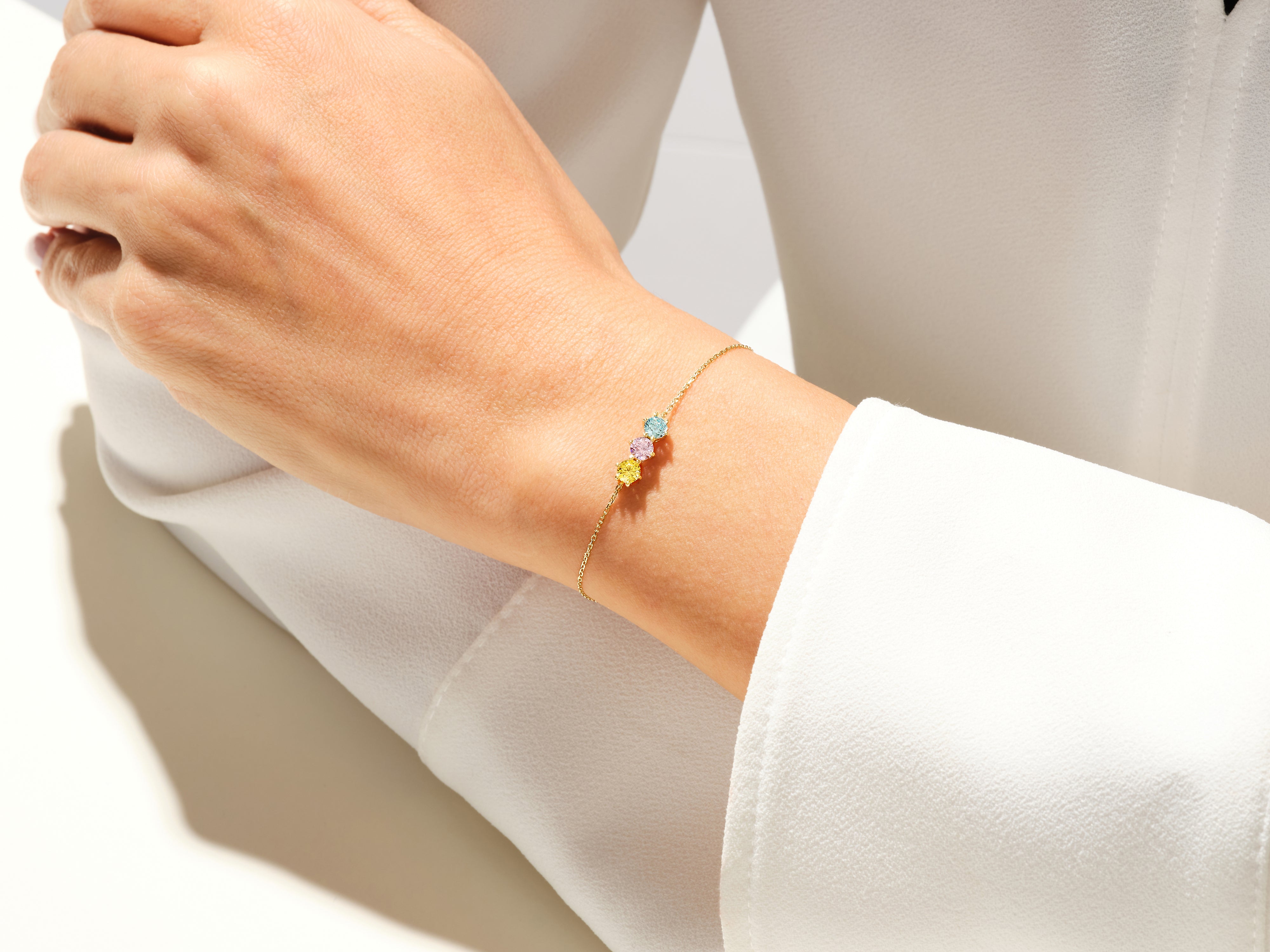 Gold bracelet with colorful gemstones on a woman's wrist