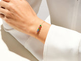 Gold bracelet with colorful gemstones on a woman's wrist
