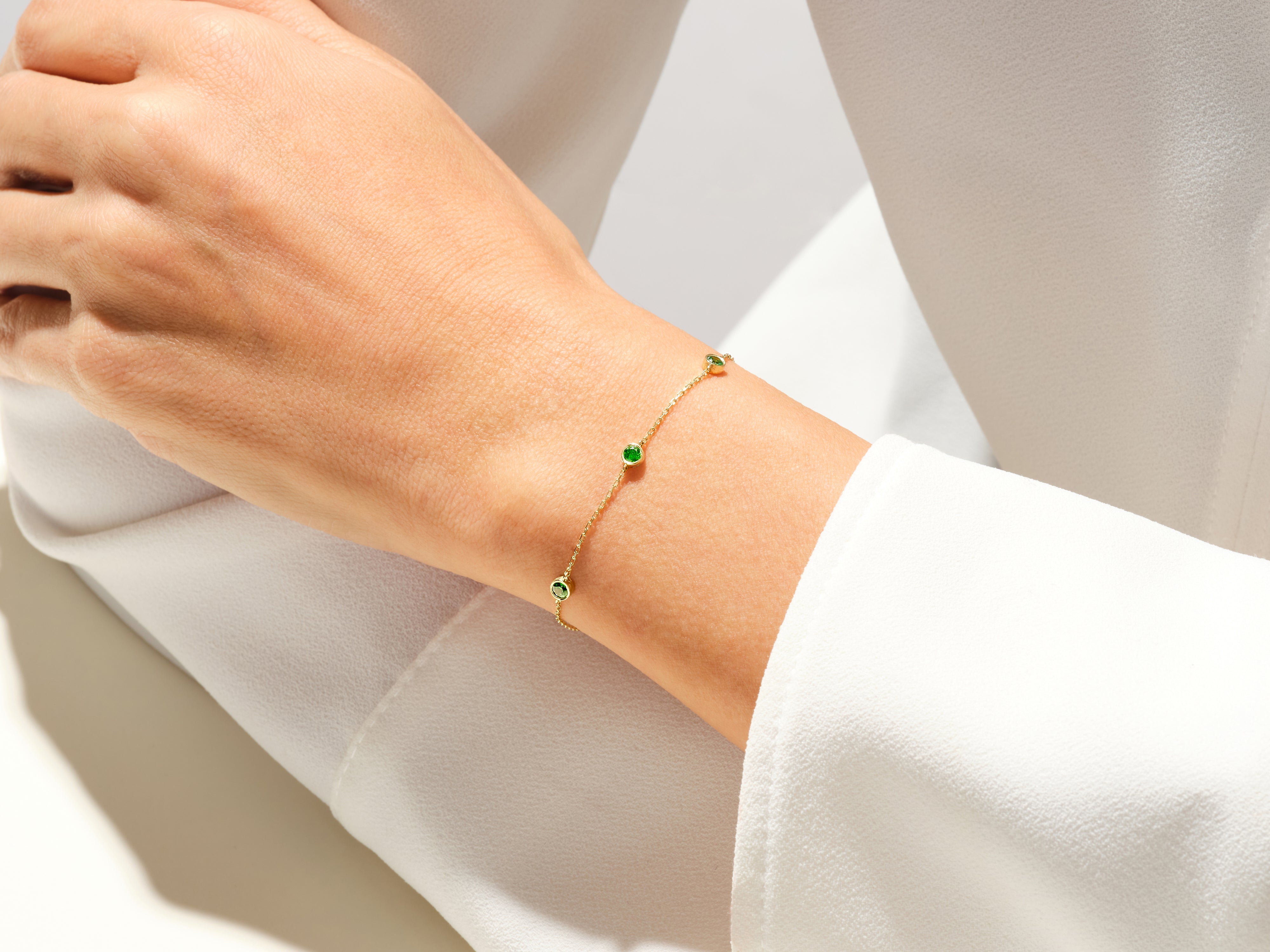 Gold bracelet with emeralds on a woman's wrist