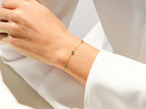 Gold bracelet with emeralds on a woman's wrist