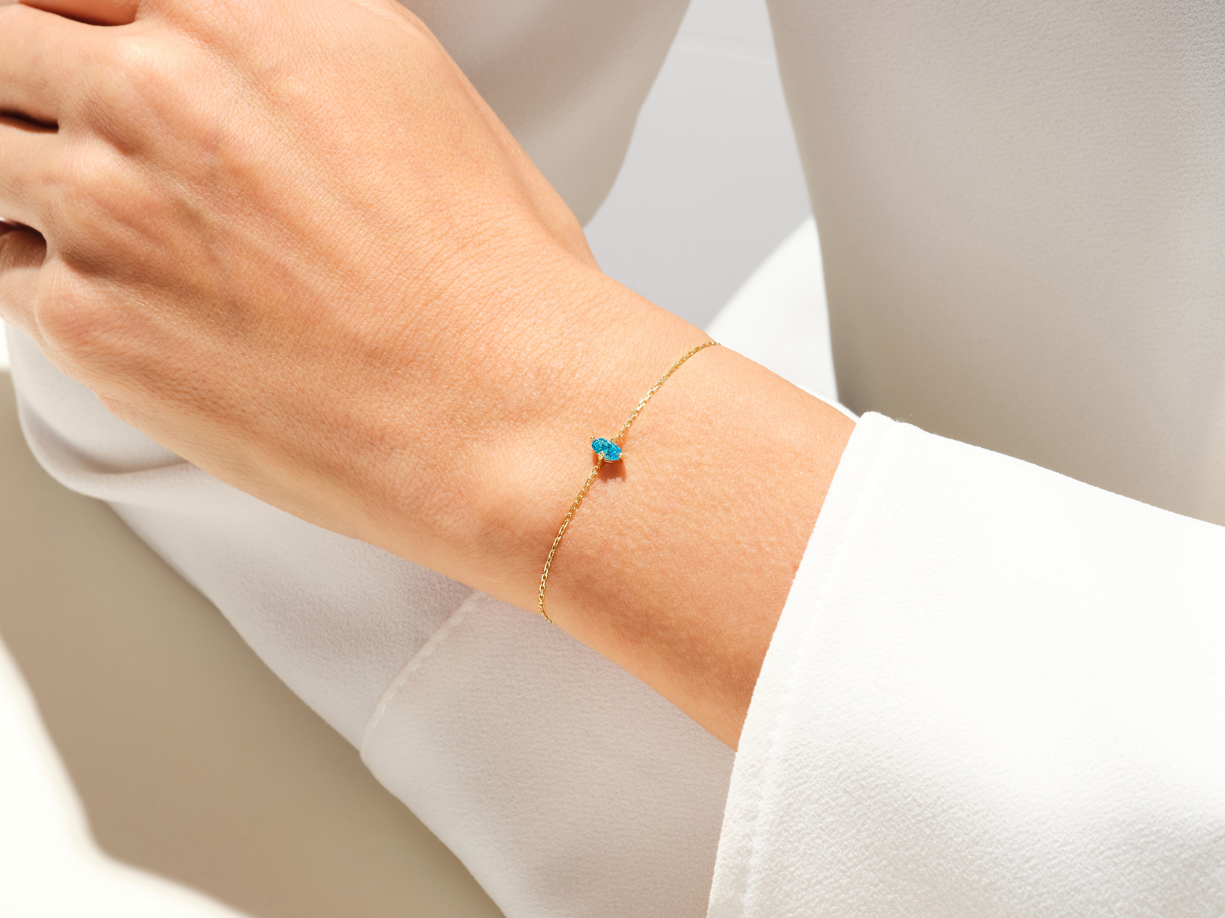 Gold chain bracelet with small blue gemstone accents