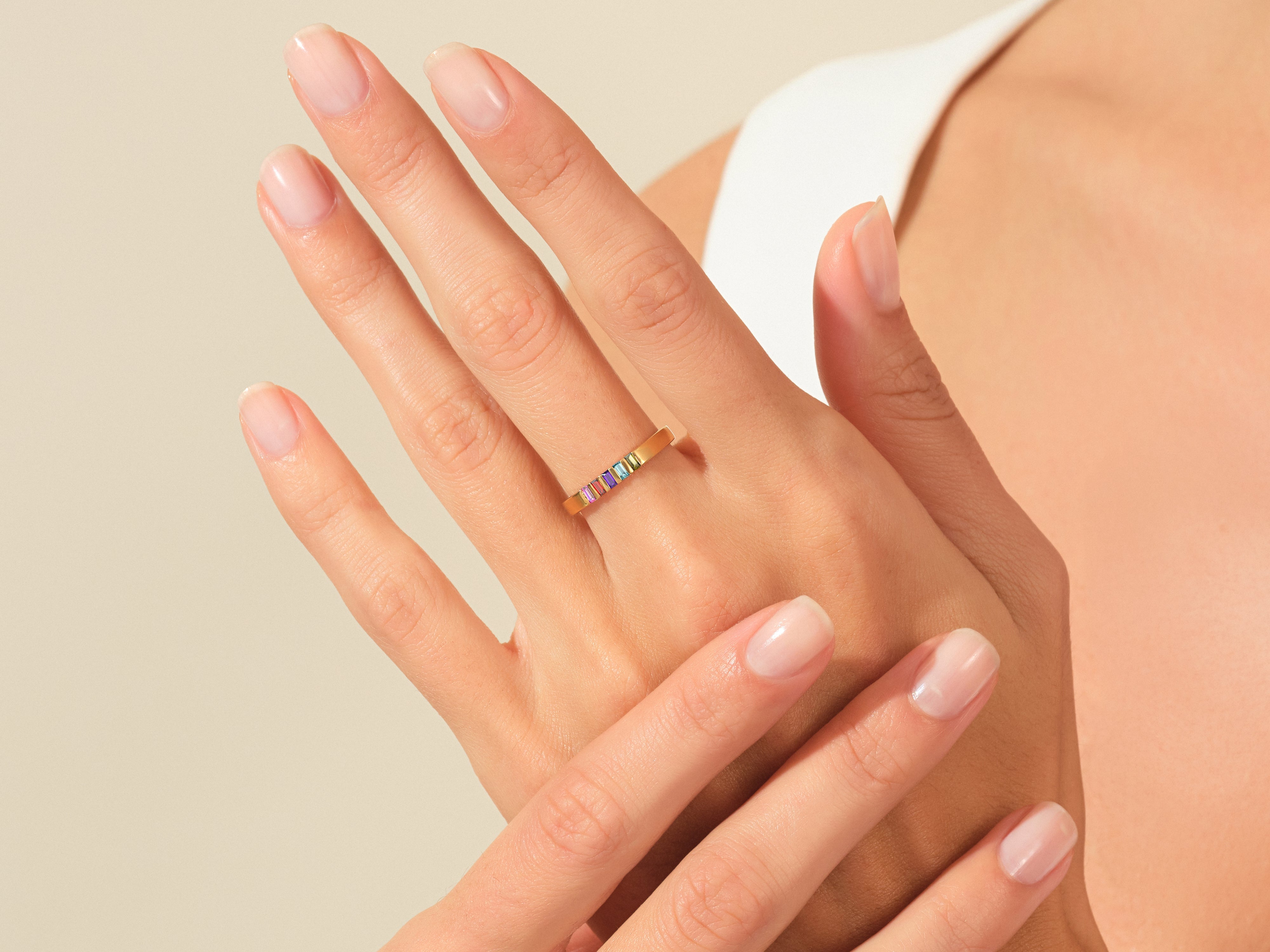 Gold ring with colorful gemstones on a woman's hand