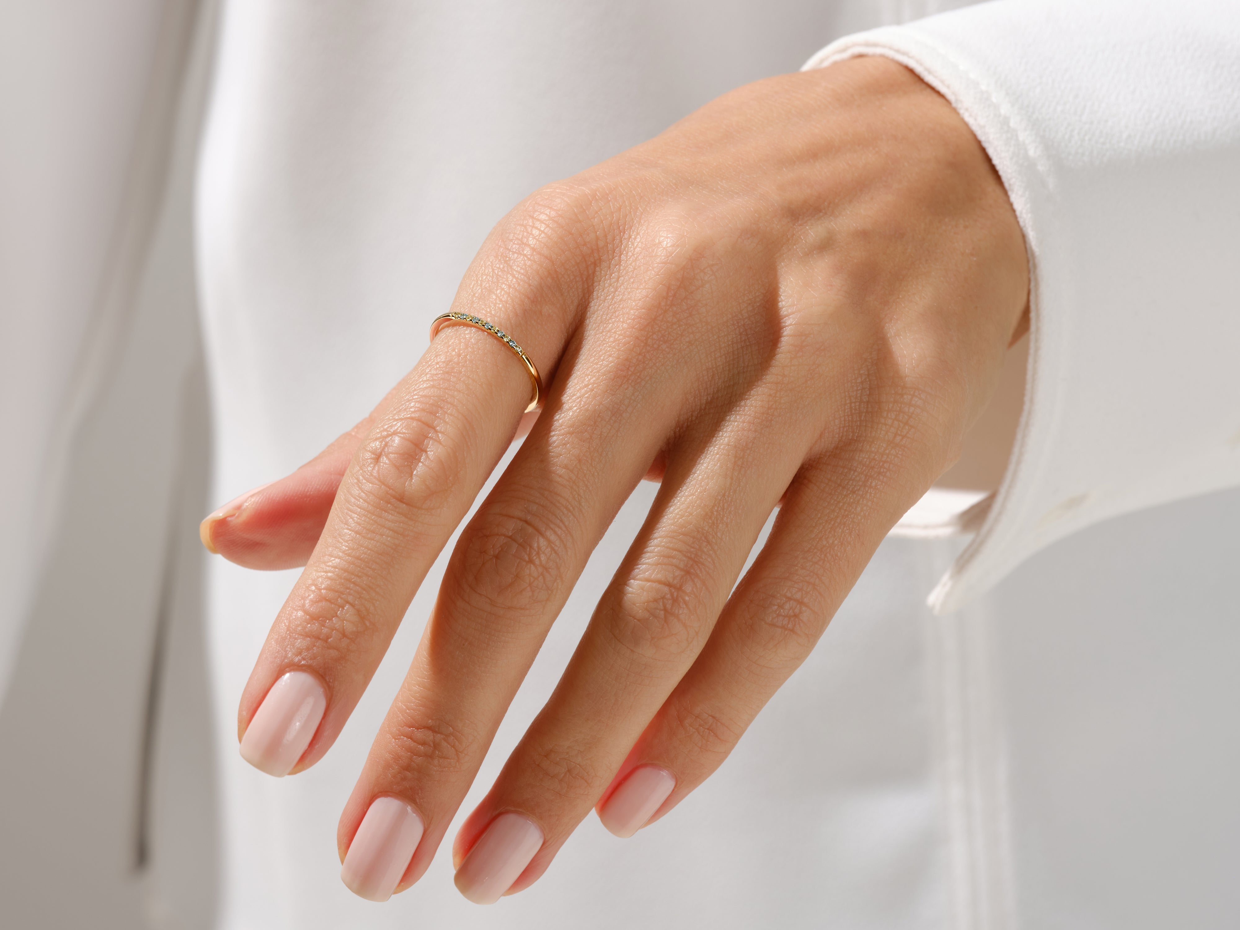 Delicate gold ring with diamonds on a woman's hand