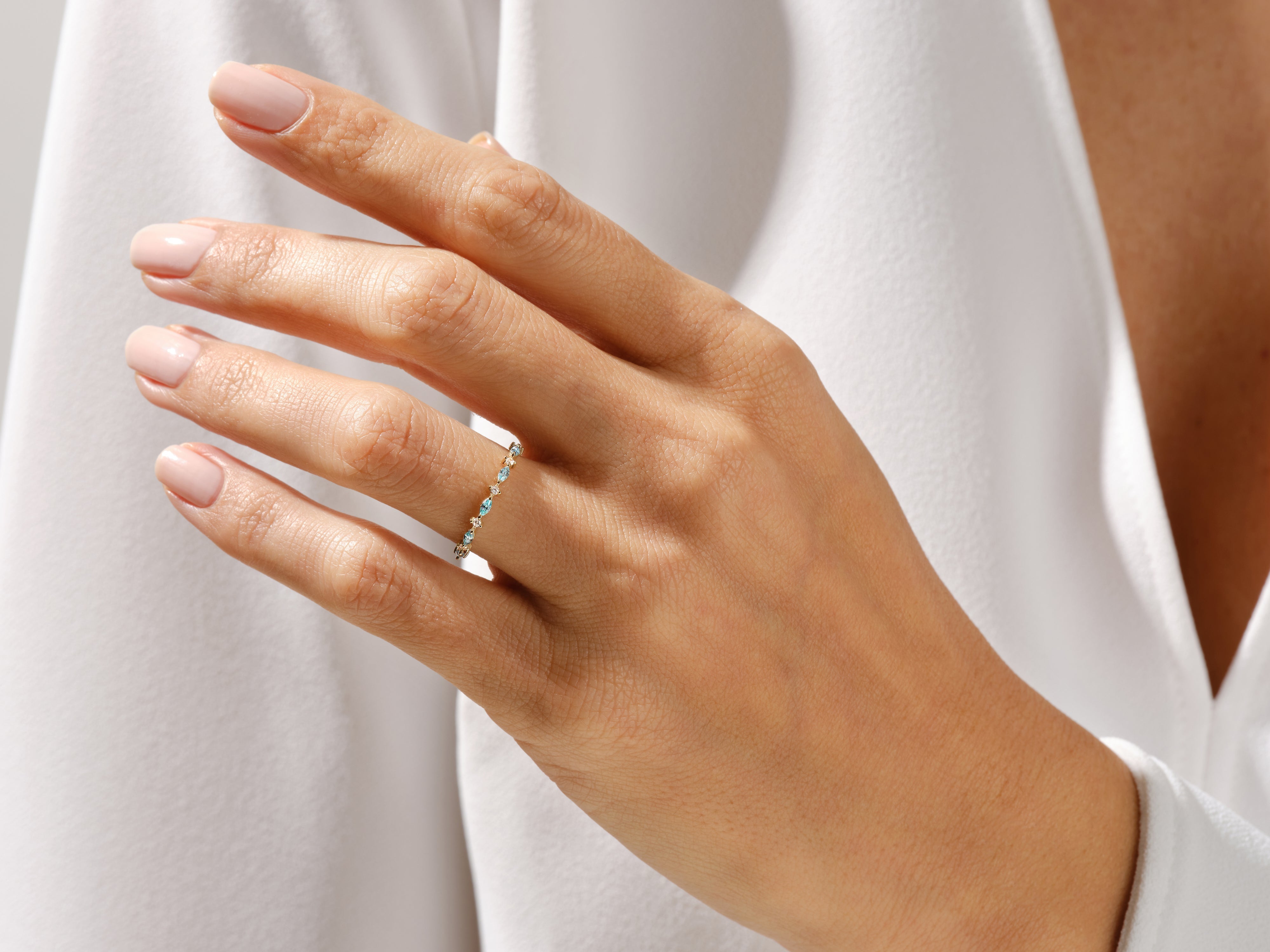 Delicate gold ring with turquoise and diamond accents on a woman's hand