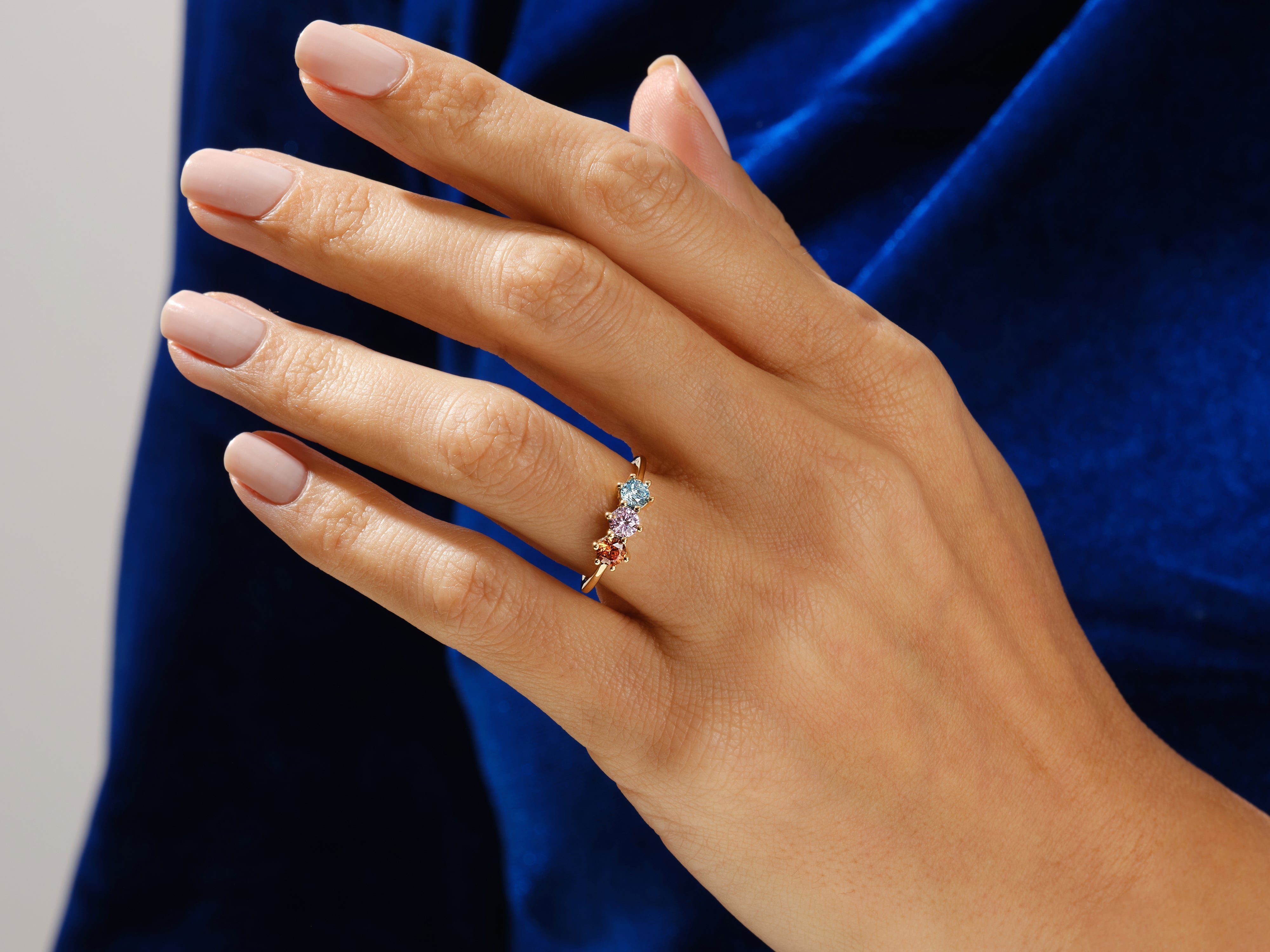 Gold ring with colorful gemstones on a hand