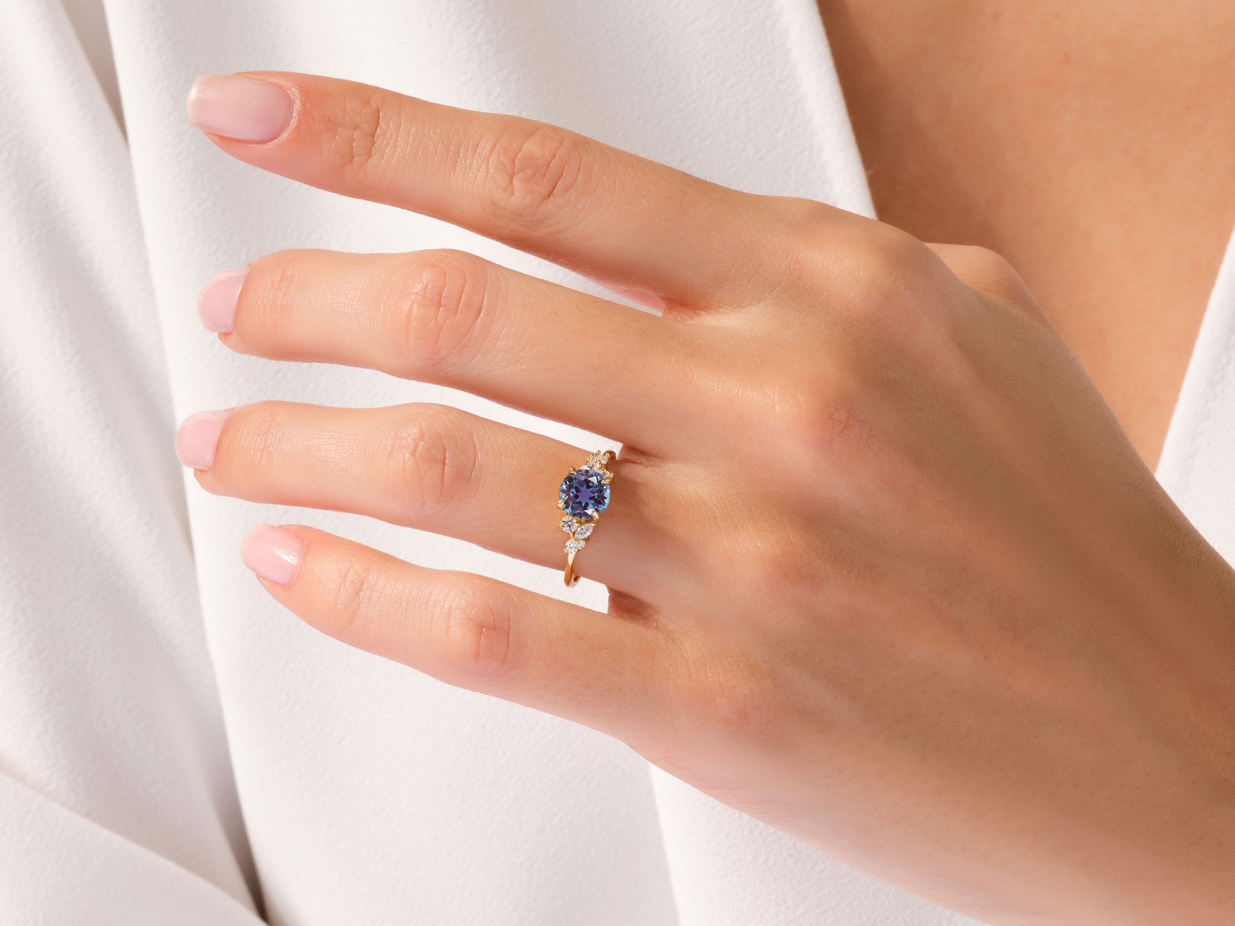 Gold ring with blue sapphire and diamonds on a woman's hand