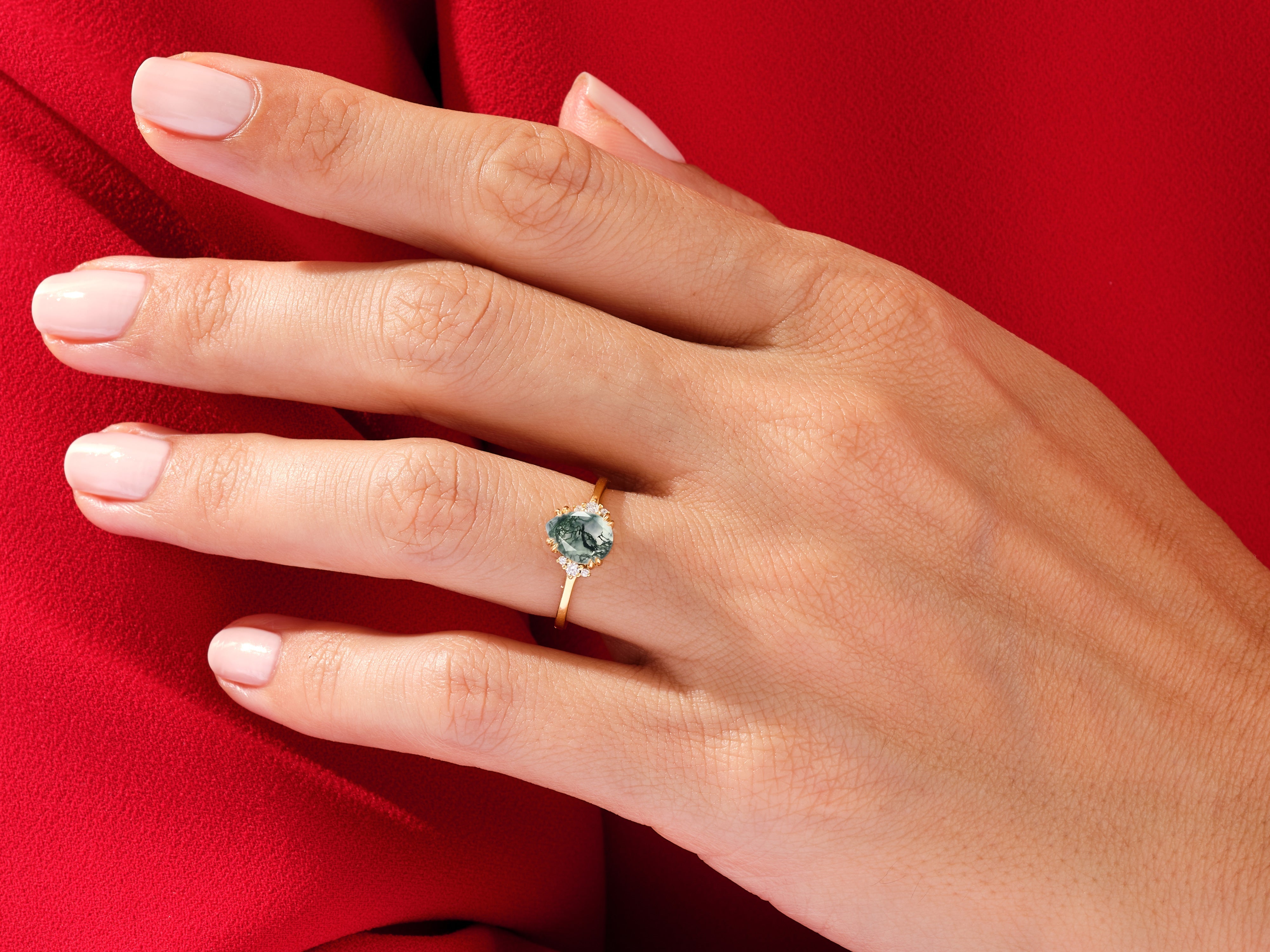 Gold ring with moss agate and diamonds on a hand