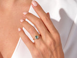Gold ring with moss agate and diamonds on a woman's hand