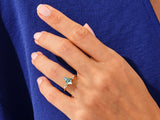 Jewelry: Gold ring with blue gemstone and diamonds on hand