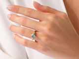 Gold ring with aquamarine gemstone and diamonds on a hand