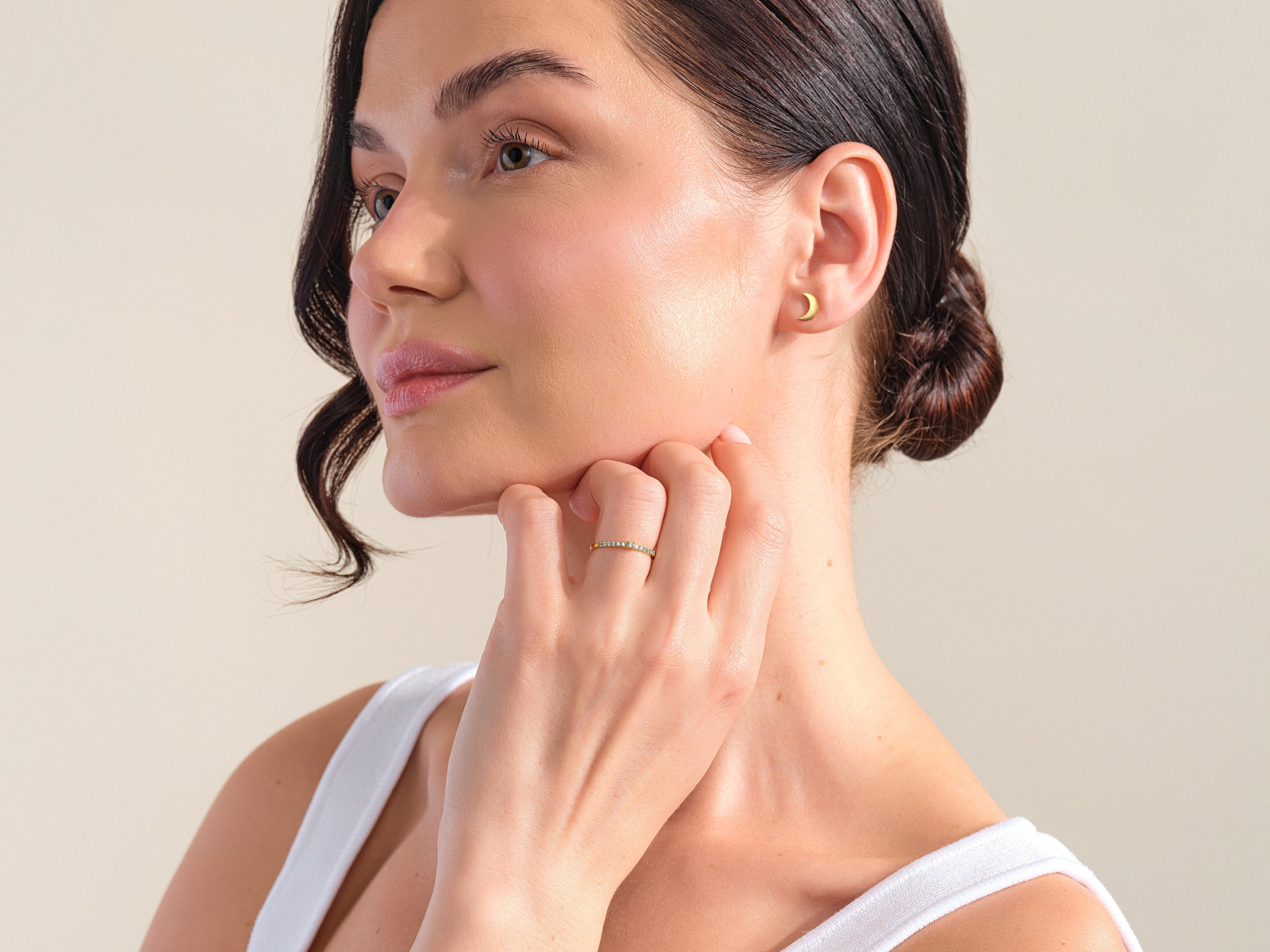 Gold crescent moon earring and diamond band ring on model