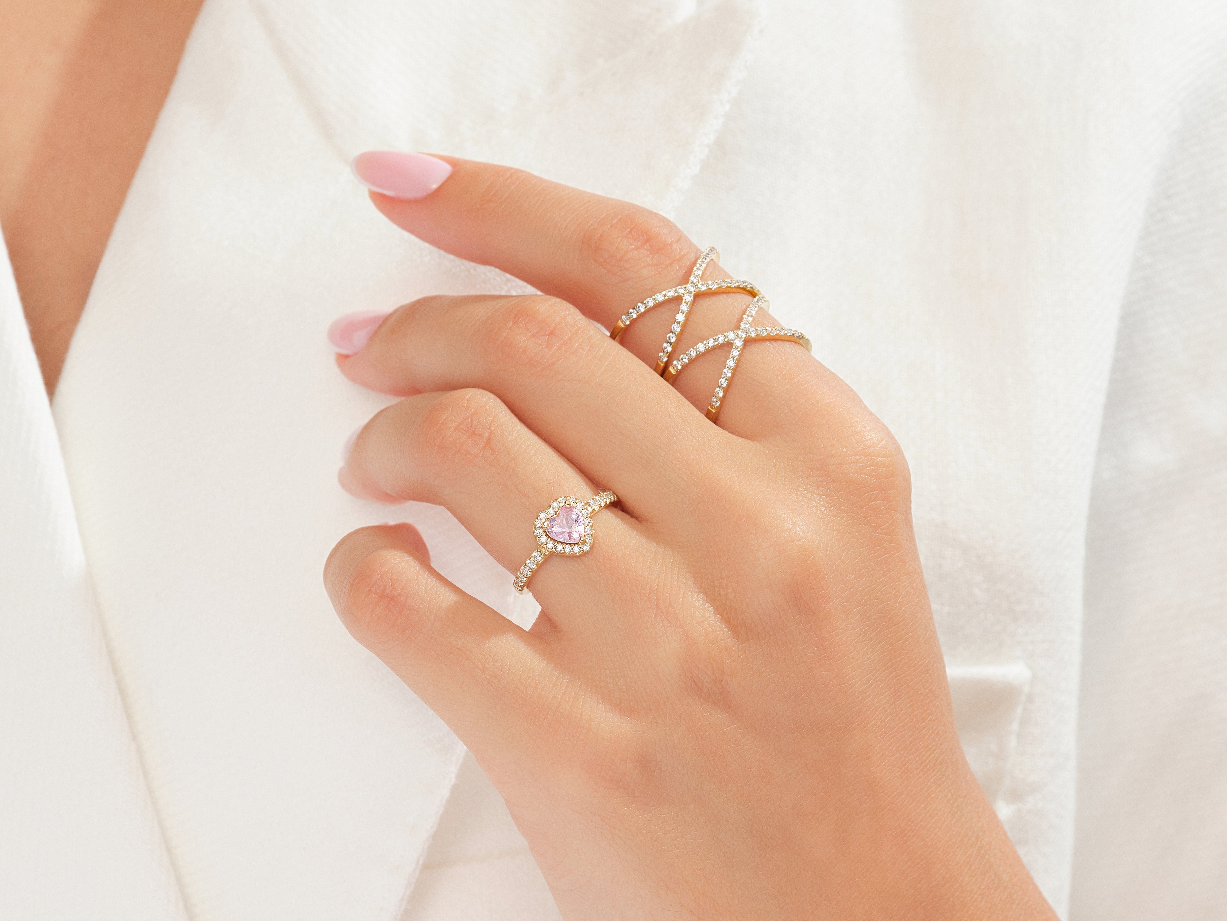 Diamond rings on hand, heart shape pink gemstone, criss cross band