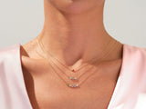 Gold necklaces with colorful gemstone pendants on a woman's neck